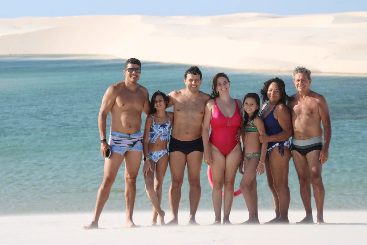 Grupo de viajantes reunido na beira da lagoa durante passeio guiado nos Lençóis Maranhenses